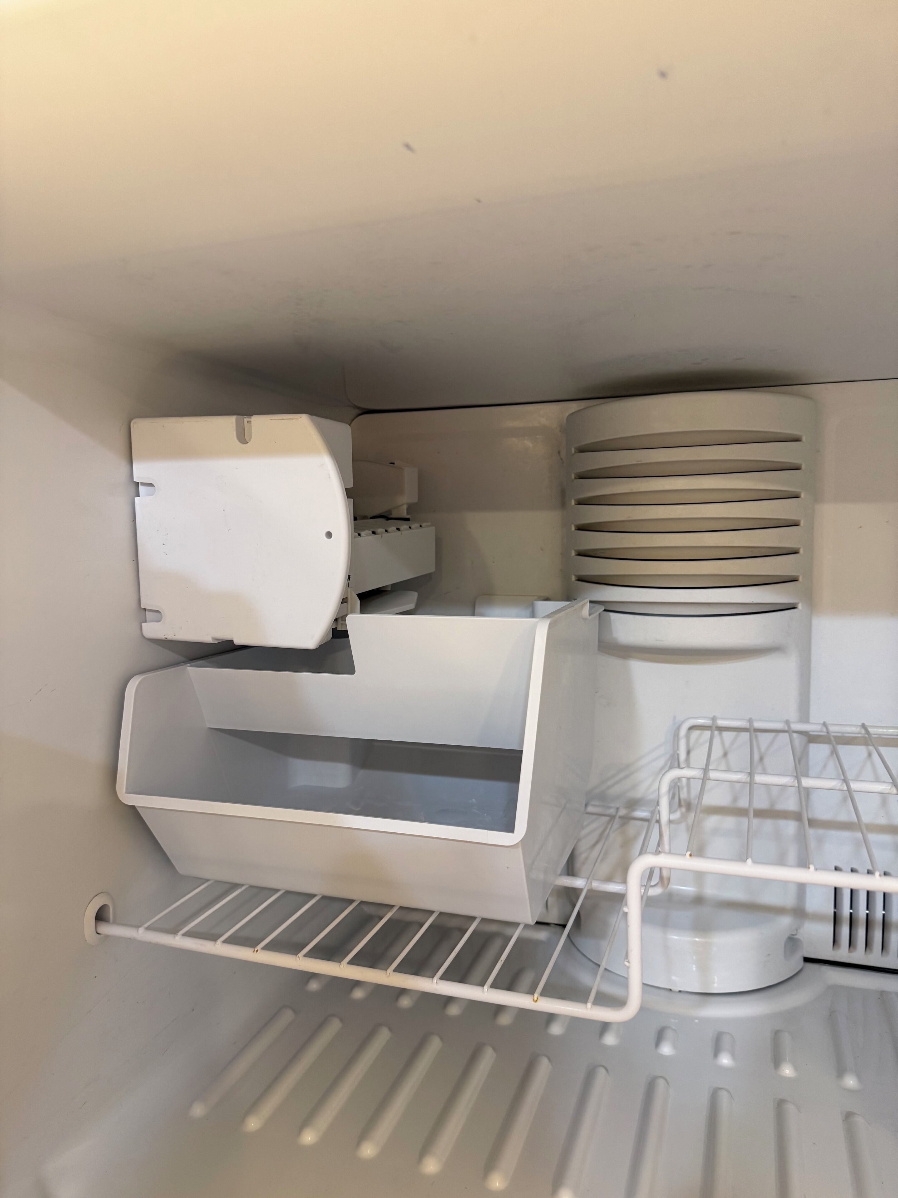A compact, white interior with a built-in printer, a small storage compartment, and a metal shelf unit.