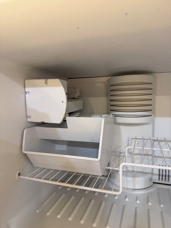 A compact, white interior with a built-in printer, a small storage compartment, and a metal shelf unit.