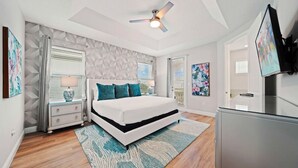 A bedroom with a bed, nightstands, a ceiling fan, and a TV. - Ohana Dream 6 bedrooms, 5 bathroom, private pool, 10 mins from Disney!  (Kissimmee)