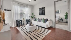 Una sala de estar moderna con un sofá blanco, una mesa de centro redonda y una alfombra a rayas.
