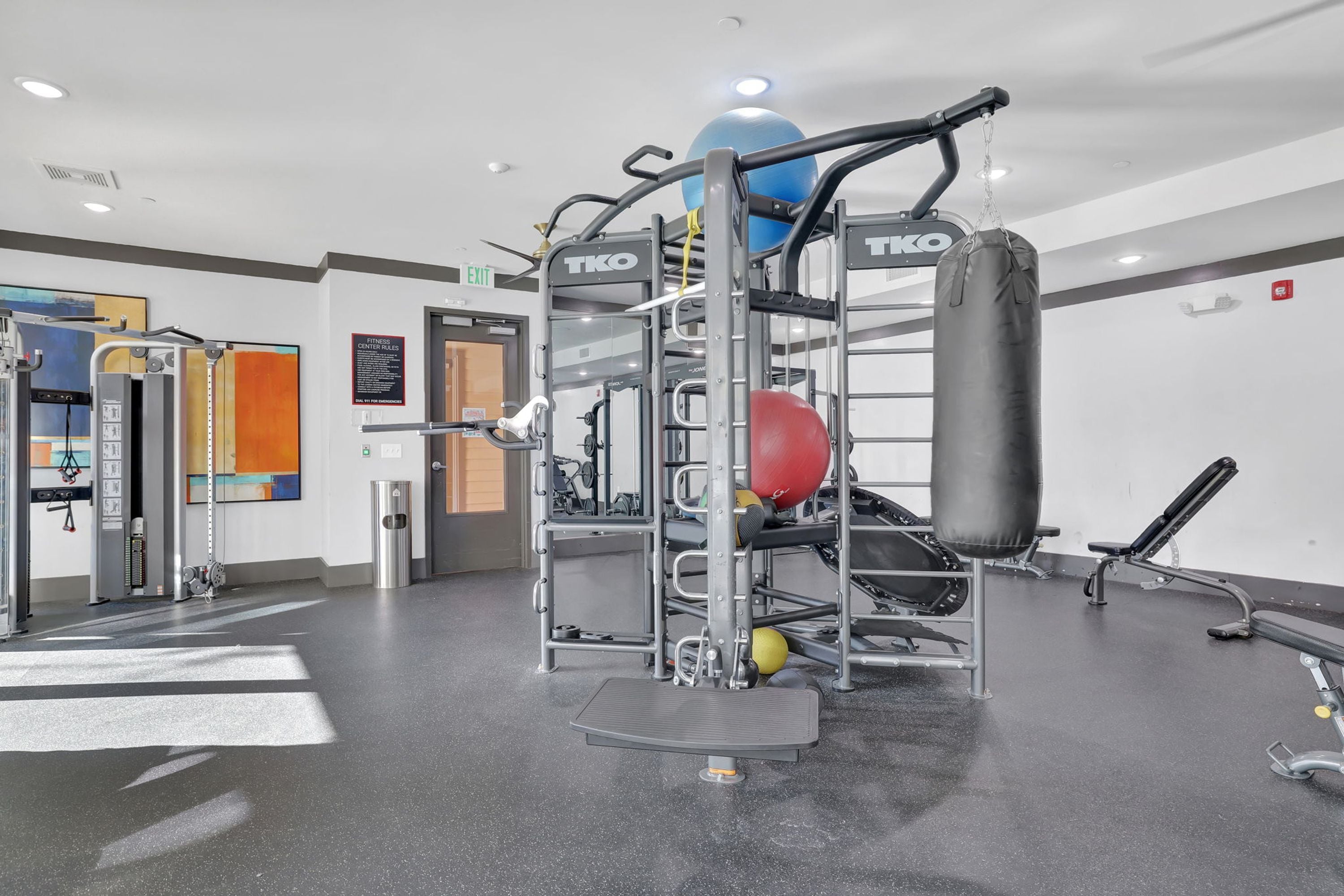 Ein Fitnessraum mit Klimmzugstange, Sandsack und einer Stehplattform.