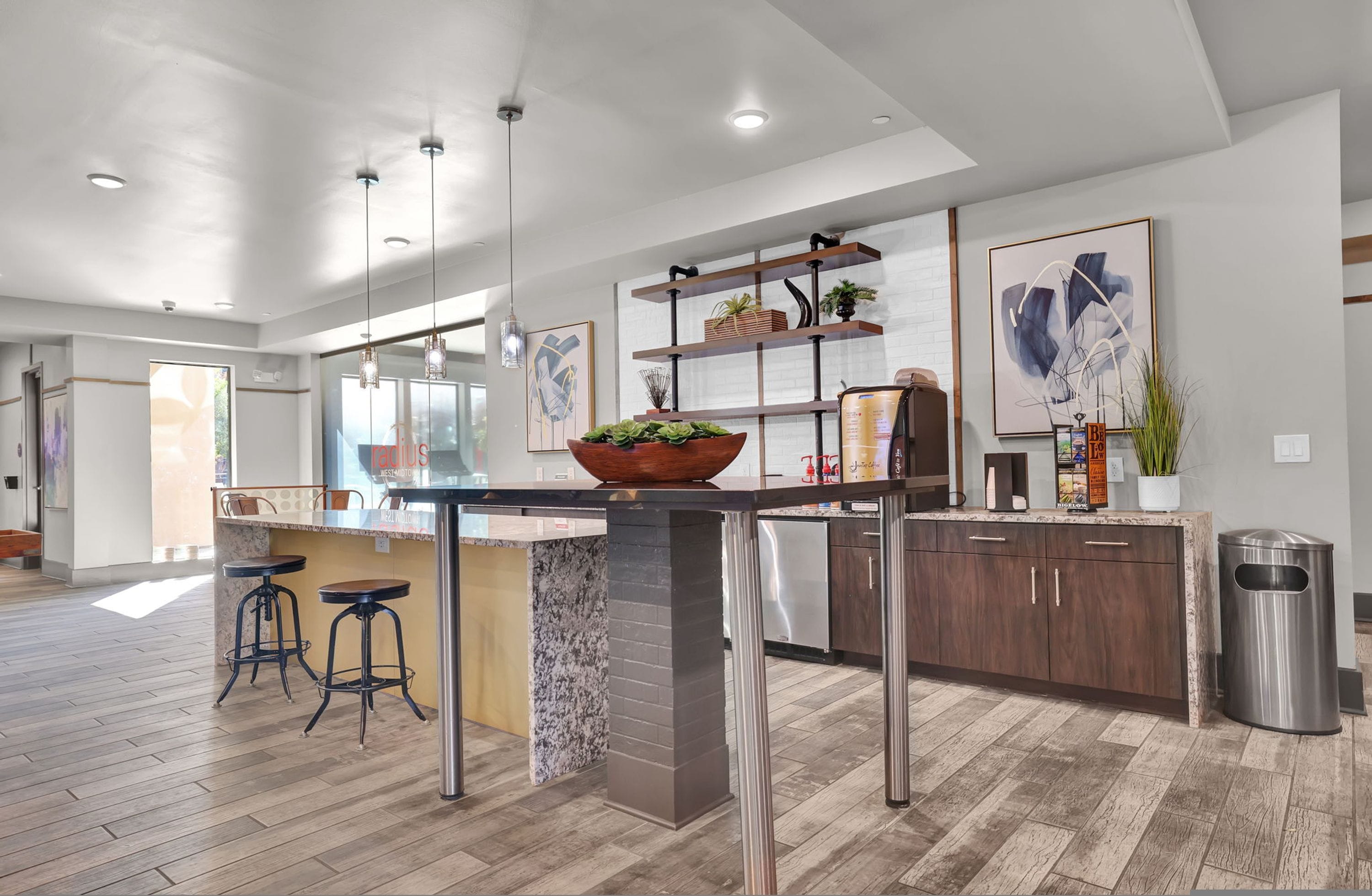 Une cuisine moderne dotée d’un îlot central, de tabourets de bar, de meubles en bois et d’une poubelle en acier inoxydable.