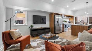 Un salon moderne avec un canapé, une table basse et un téléviseur.