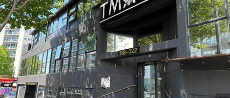 A building with a sign reading "TMACS" and the address "118-122".