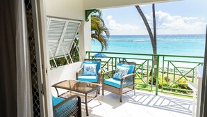 A balcony with wicker furniture and a view of the ocean. - Charming 2-bedroom condo, with WiFi, AC & uninterrupted sea views in Bridgetown  (Bridgetown)