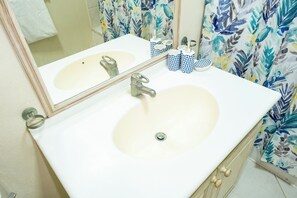 Regadera, secadora de cabello, toallas, papel de baño