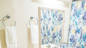 A bathroom with a toilet, sink, and shower curtain. - Charming 2-bedroom condo, with WiFi, AC & uninterrupted sea views in Bridgetown  (Bridgetown)