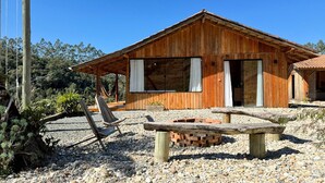 Eine Holzjagdhaus mit einem großen Fenster, einer Feuerstelle und einer Hängematte.