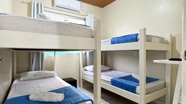 A bunk bed room with white bedding and blue accents.