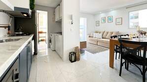 A modern kitchen with a built-in stove, a sink, and a dining area with a table set for two.