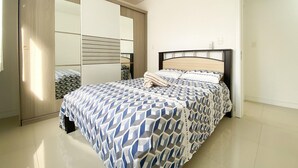 Un dormitorio con cama, armario y espejo.
