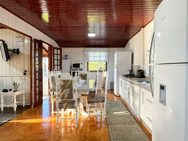 A compact kitchen with white cabinets, a microwave, and a Bosch refrigerator.