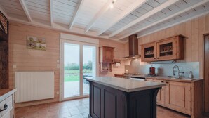 Una cocina amplia con armarios de madera, una isla grande y vistas al exterior.