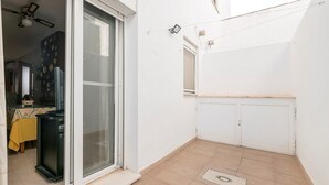 Un petit patio clos, avec une porte-fenêtre coulissante donnant sur un coin repas.