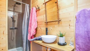 A wooden cabin bathroom with a shower, a sink, and a mirror. - Gorgeous home in Rochessauve with WiFi (Rochessauve)