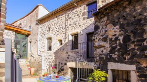 A stone building with a balcony and a table set for dining. - Gorgeous home in Rochessauve with WiFi (Rochessauve)