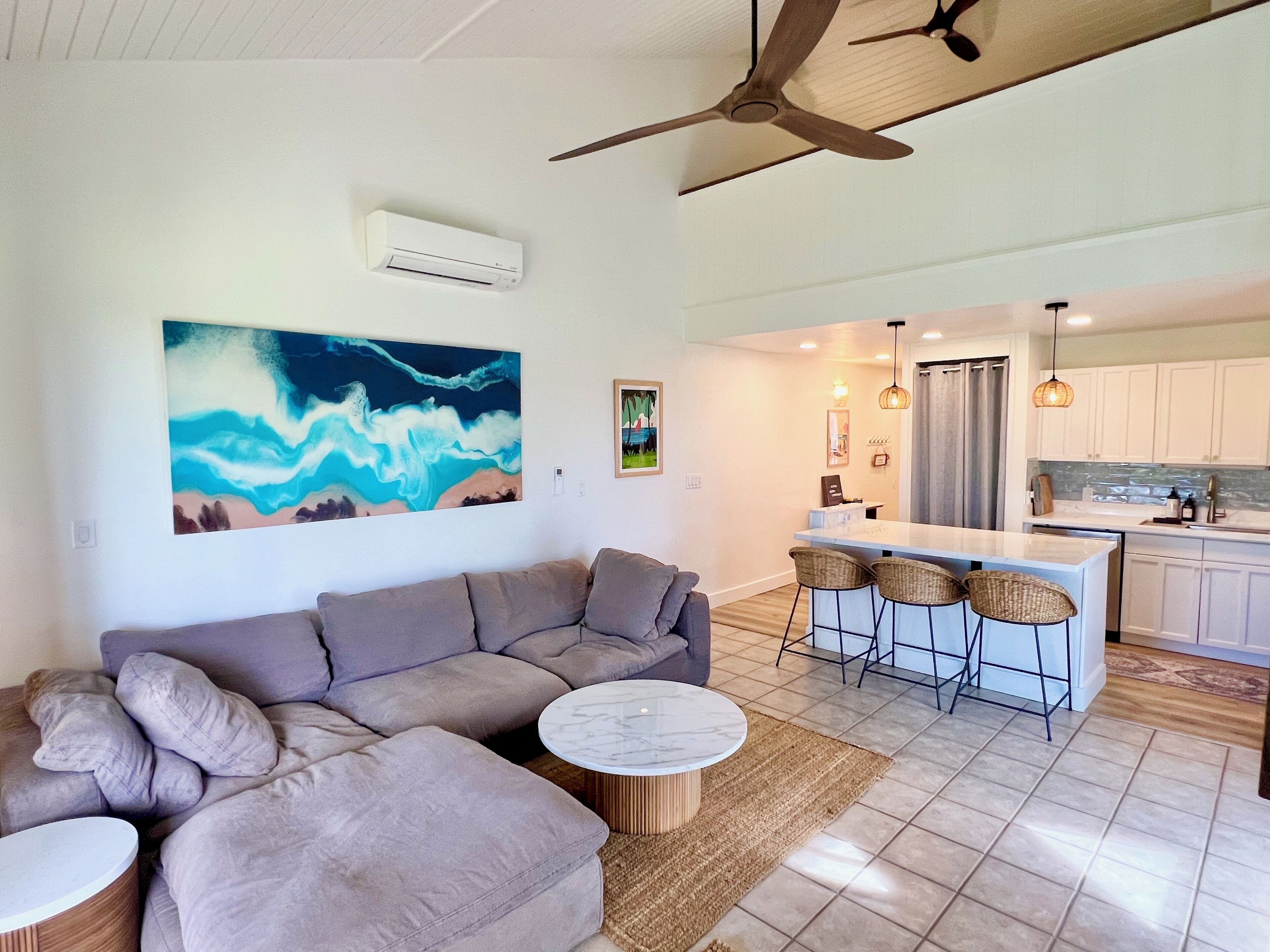 A modern living room with a sectional sofa, a round coffee table, and a large abstract painting.