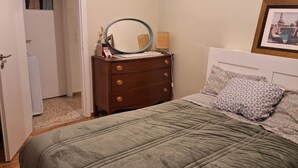 A bedroom with a bed, dresser, and a mirror.