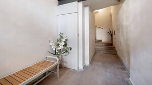 A hallway with a bench, a door, and a staircase leading to another room. - Holiday Apartment "Viasambuco" with Private Terrace & Wi-Fi (Iseo)
