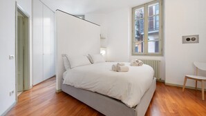 A bedroom with a bed, a window, a radiator, and a chair. - Holiday Apartment "Viasambuco" with Private Terrace & Wi-Fi (Iseo)