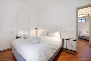 Une chambre à coucher avec un grand lit, une table de chevet avec une lampe et un miroir.