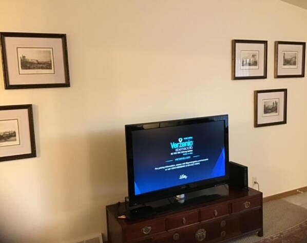 A television on a wooden cabinet with a blue screen displaying 'Verzenio'. - Your home away from home (Manitowoc)