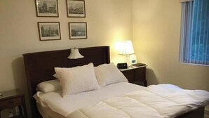 A neatly made bed with white bedding in a hotel room.
