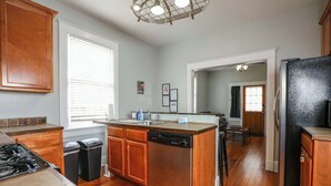 A kitchen with wooden cabinets, a dishwasher, a stove, and a refrigerator.