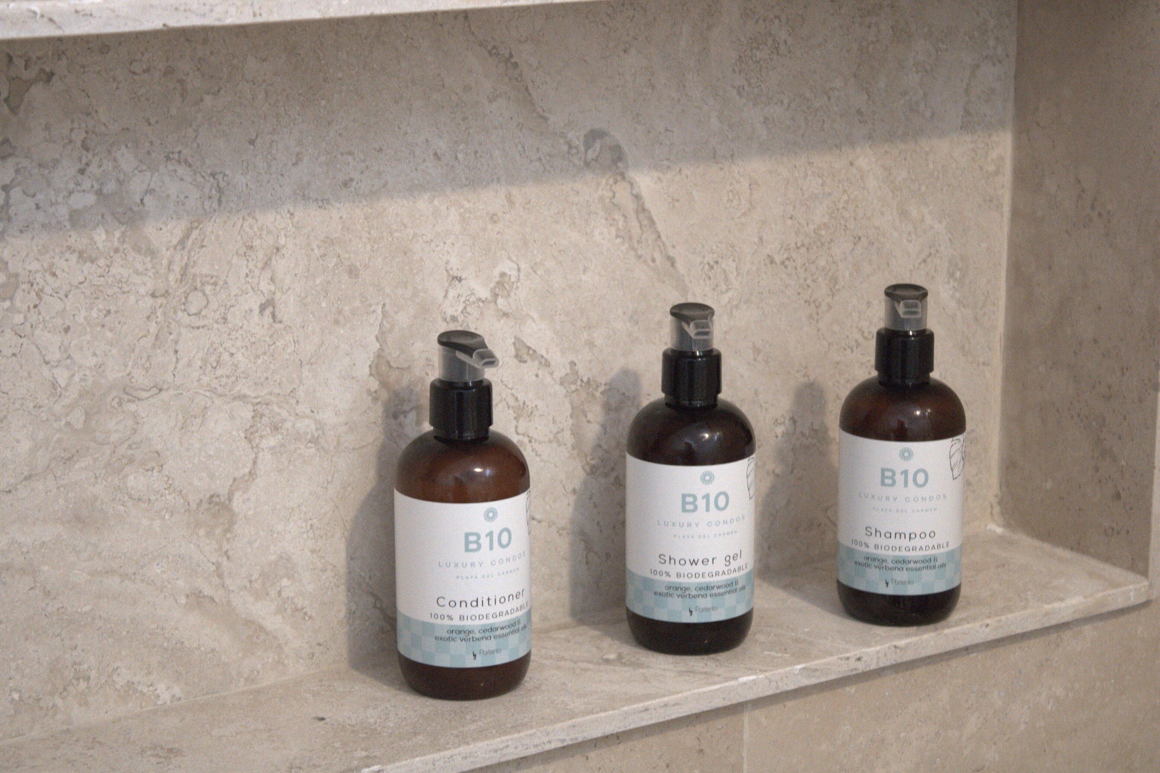 Trois bouteilles d’après-shampoing et de gel douche B10 sont posées sur une étagère.