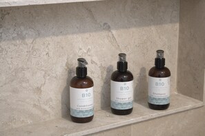 Drei Flaschen B10 Conditioner und Duschgel stehen auf einem Regal.