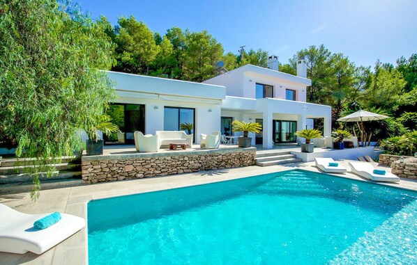 Relax by the outdoor pool surrounded by lush gardens and seating areas.