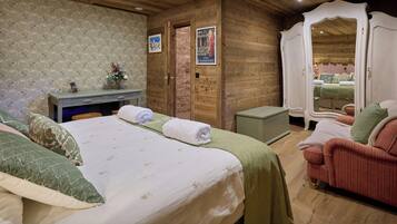 Een knus slaapkamer met een bed, bureau en spiegel.