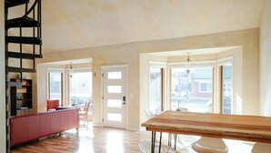 A spacious kitchen with a wooden table and bar stools, a red bench, and a staircase. - Style on the Square 2-bedroom bungalow with WiFi, AC in Petersburg (Petersburg)