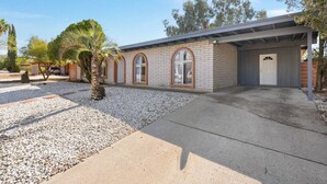 A two-story building with a covered driveway and a gravel driveway.
