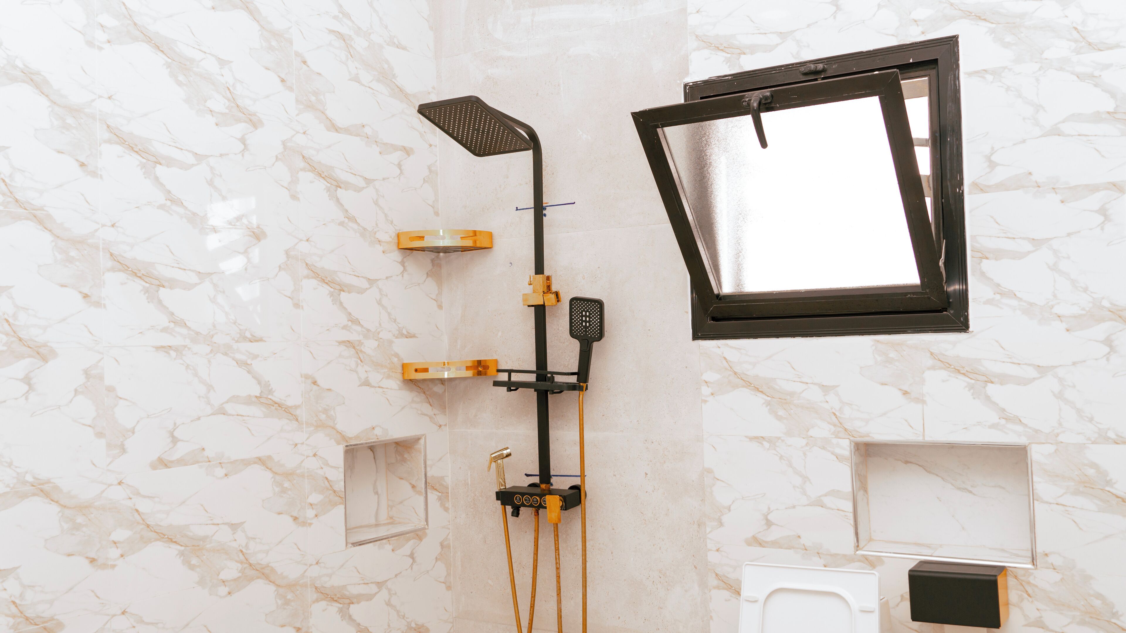 Ein Badezimmer mit Dusche, Fenster und Toilette.