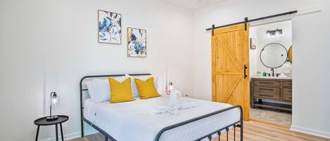 A bedroom with a bed, a bedside table, a ceiling fan, and a wardrobe.