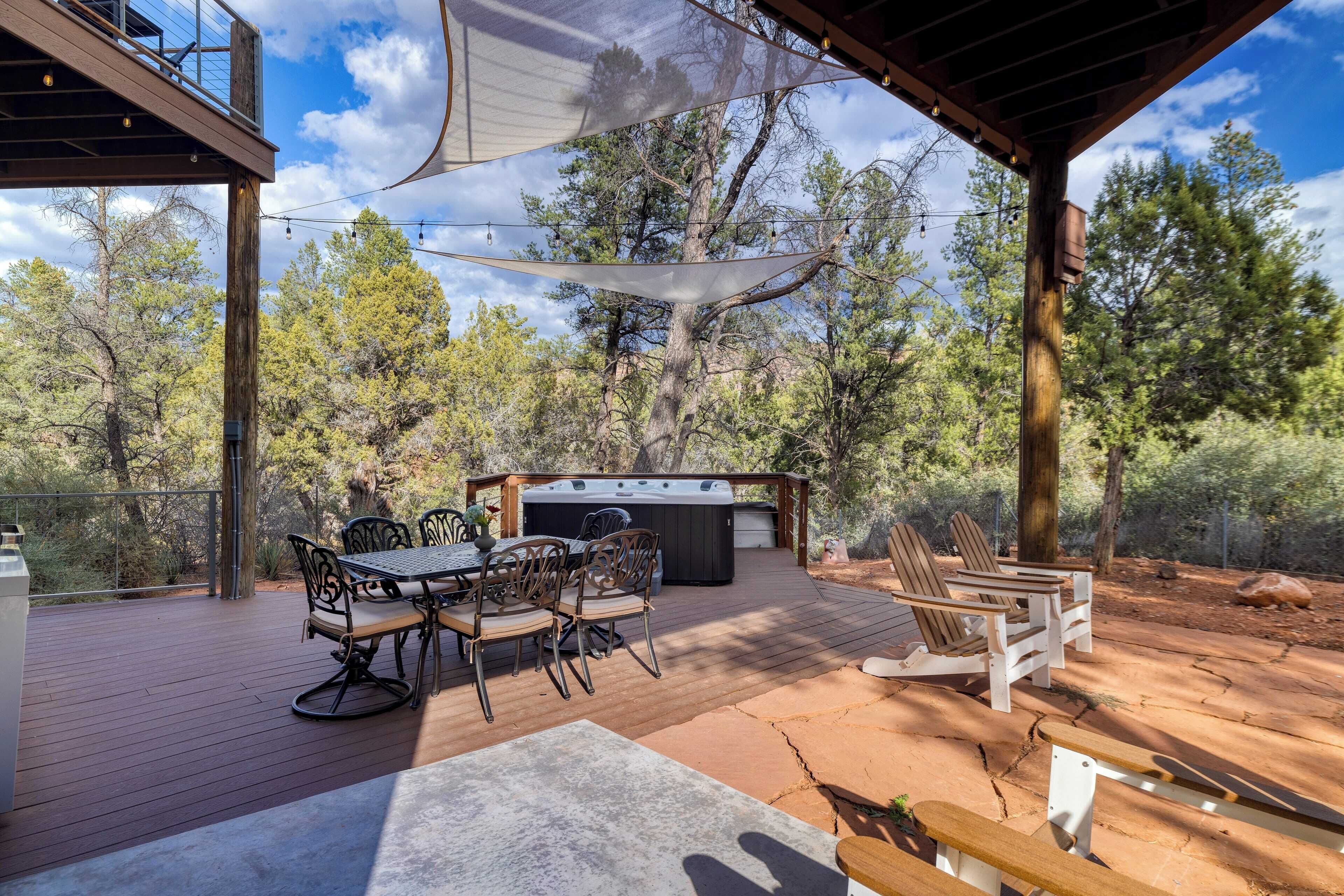 An outdoor deck with a hot tub, seating, and a pergola.