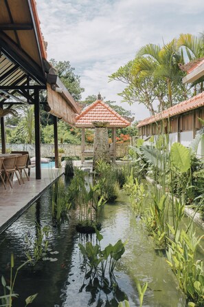 A serene garden with a pool, wooden deck, and a gazebo. - Tropical Villa Asmara (Ungasan)