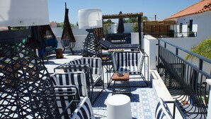 A rooftop terrace with outdoor seating, including striped lounge chairs and a table, surrounded by a metal railing. - Walking distance to several beaches, Ferragudo village, supermarkets and Portimão. (Ferragudo)