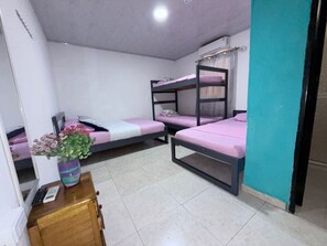 A dormitory room with bunk beds, a desk, and a vase of flowers. - Hotel Arena Mar (Santa Marta)
