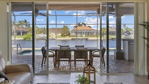 A spacious living area with a sliding glass door leading to a poolside patio.