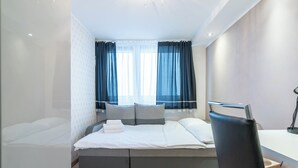 A modern bedroom with a bed, a desk, and a chair. - Park Śląski 18th Floor Apartment (Katowice)