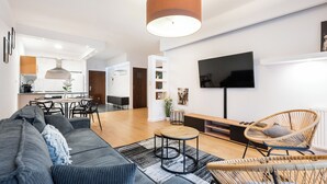 Ein modernes Wohnzimmer mit einer Couch, einem Couchtisch und einem Fernseher.