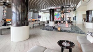 Un hall d’entrée spacieux avec un espace salon central, un bar et un design de plafond moderne.