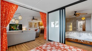Een moderne slaapkamer met een bed, een bank en een televisie.