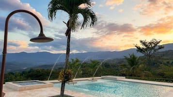 Una piscina al aire libre, sombrillas, sillones reclinables de piscina