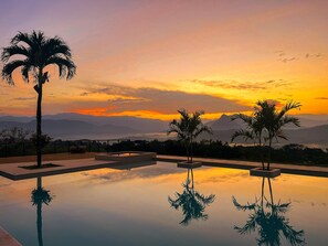 A serene pool area with palm trees and a sunset view. - Fina Estampa Country Hotel - Mayores de 10 años  (Támesis)