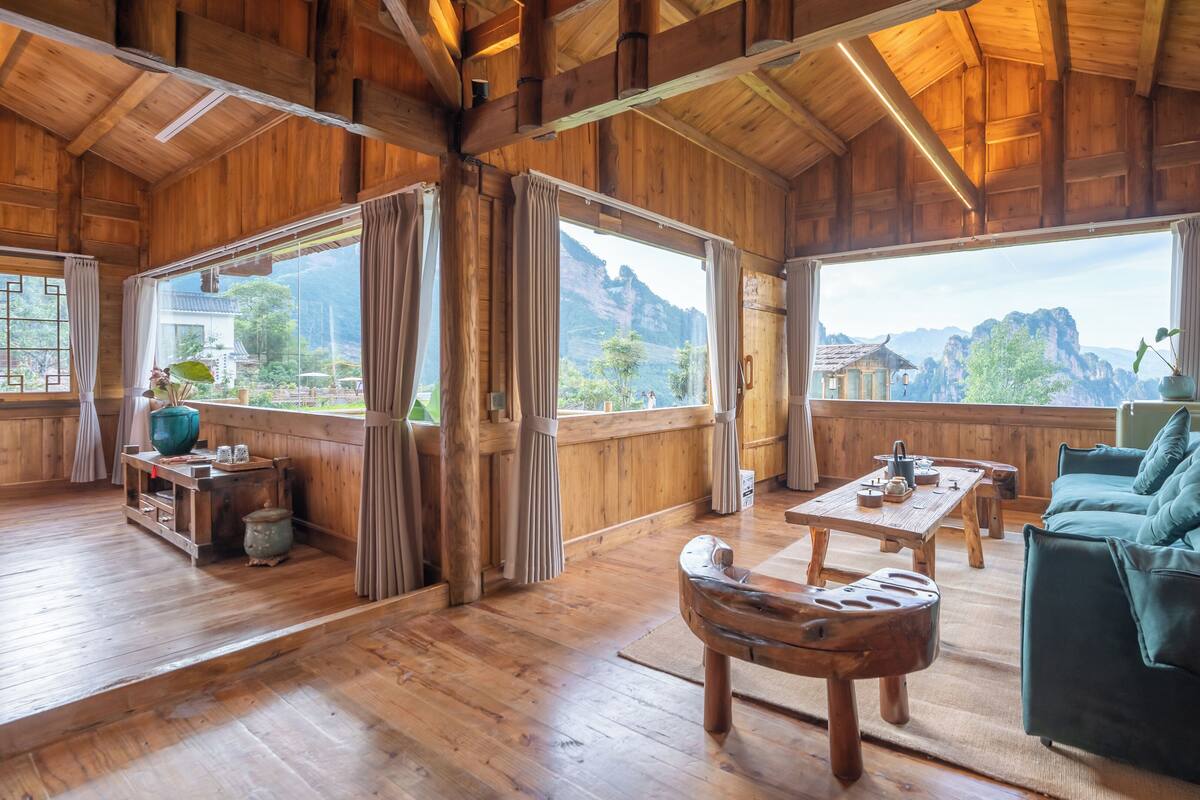 Interior de madera con sofá, mesa y cortinas.