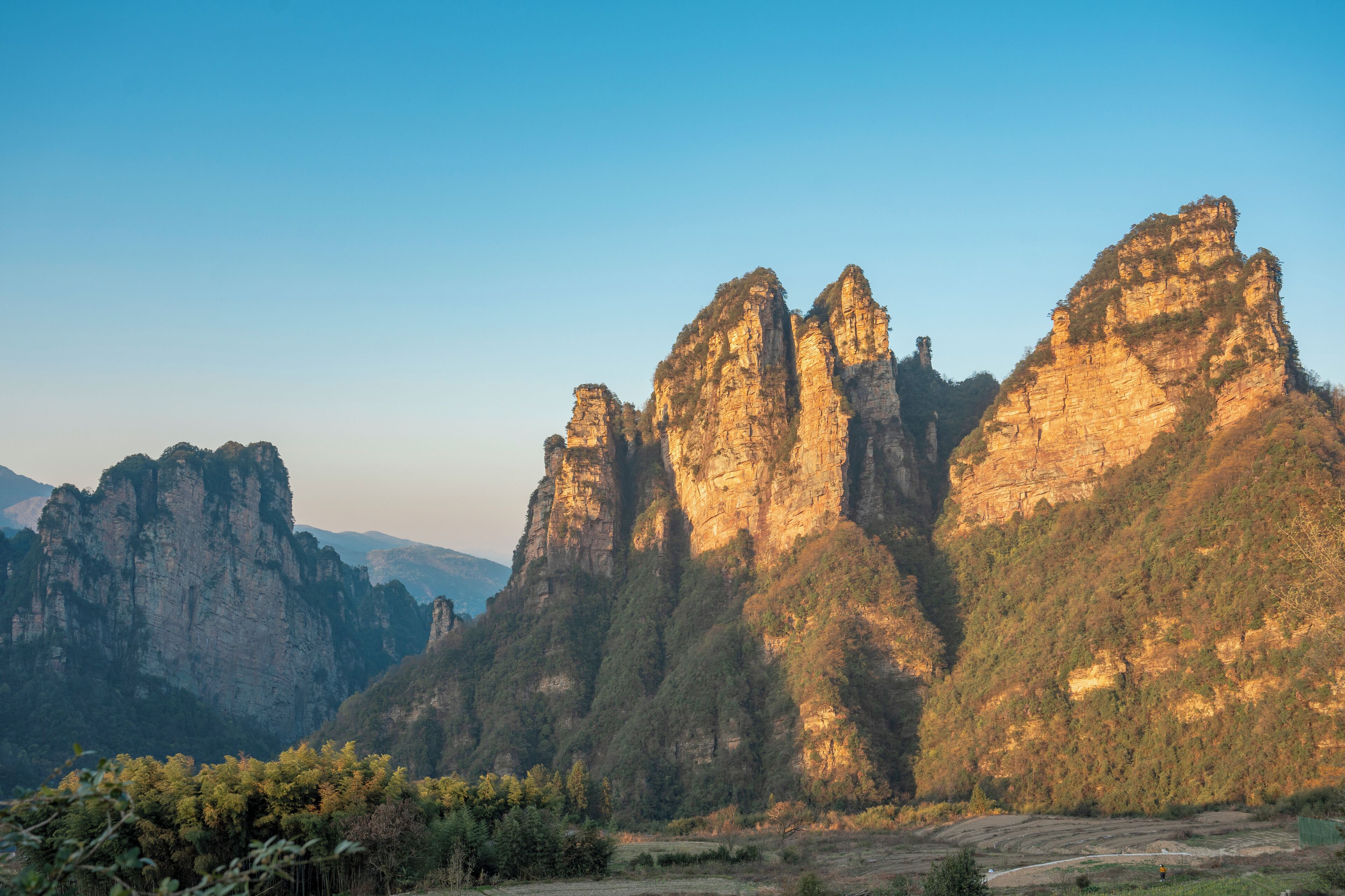 A mountainous landscape with prominent rock formations and a clear sky.