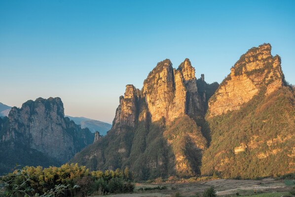 Un paysage montagneux caractérisé par d’imposantes formations rocheuses et un ciel dégagé.